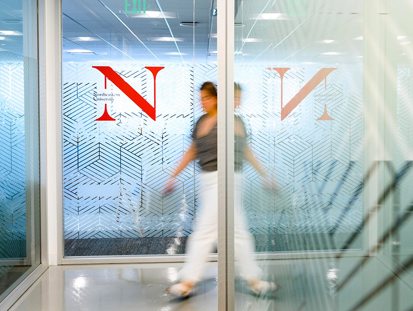 Student walking through northeastern office 