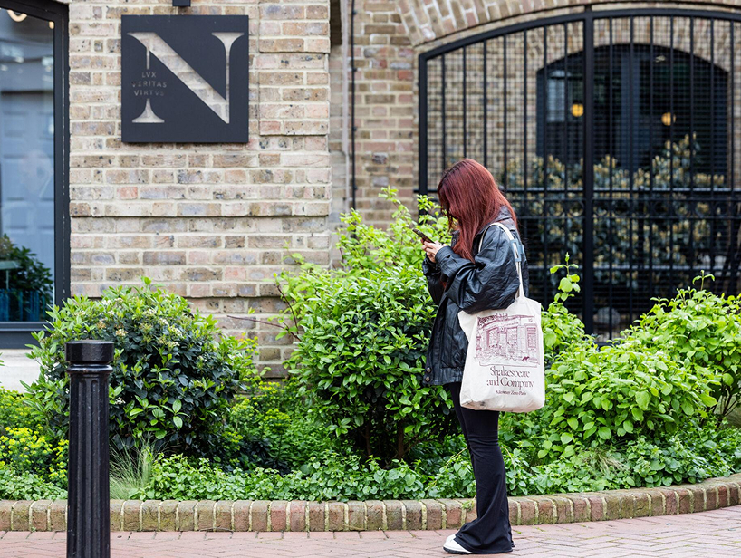 Student walking past a wall with northeastern sign on it