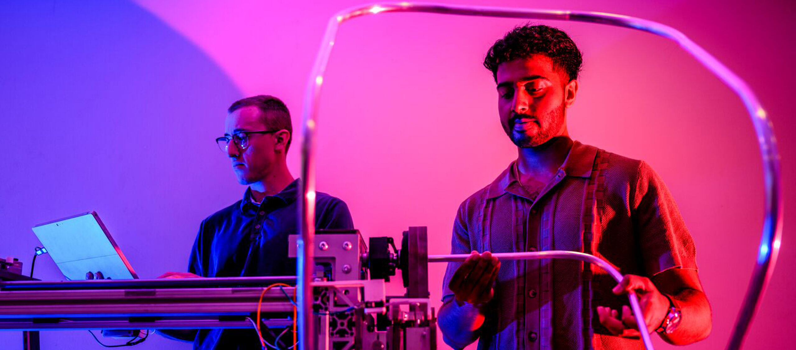 Two research students working on a science instrument together