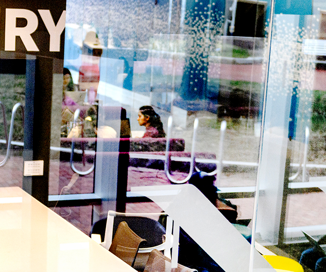 Student shown working in a build through a glass window
