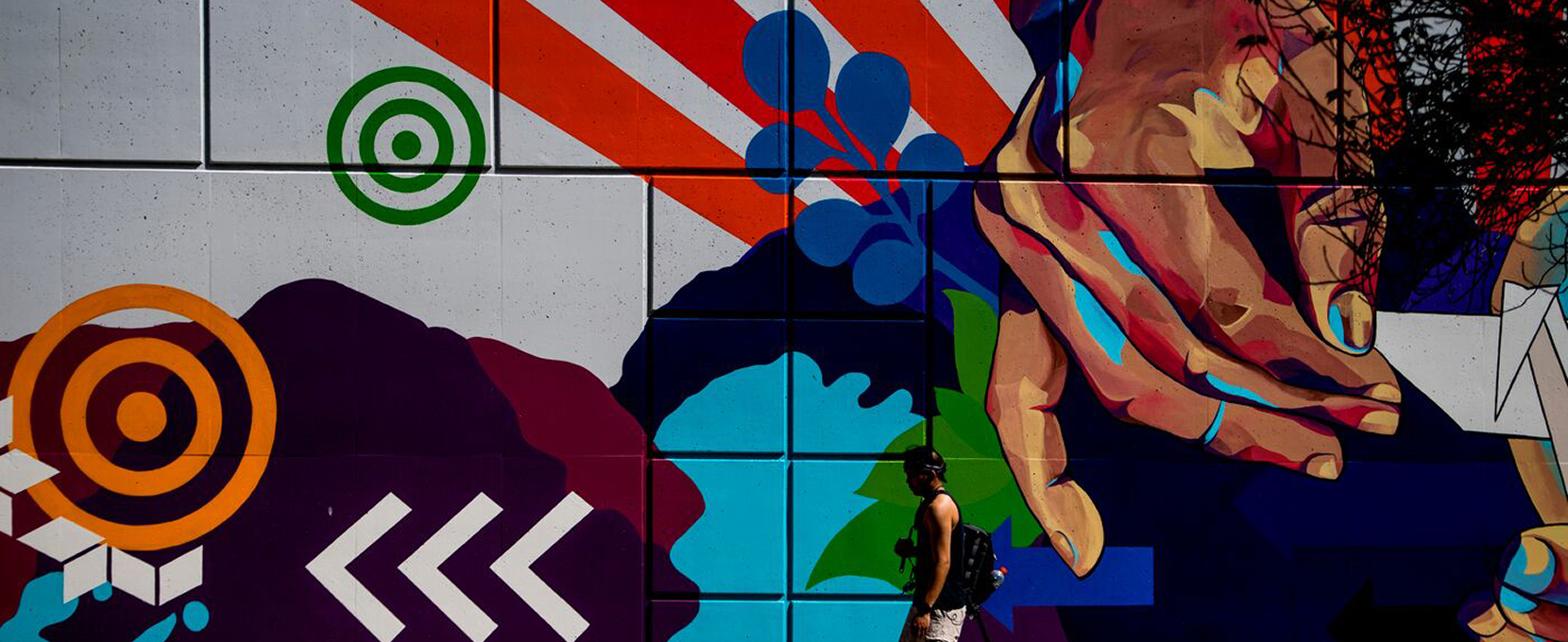 Wall mural showcasing vector shapes and a hand